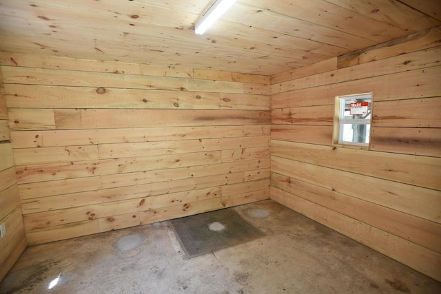 interior space featuring wooden ceiling, wooden walls, and concrete flooring