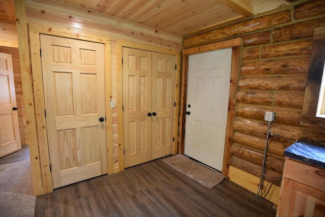 foyer with dark wood-type flooring, wood ceiling, and log walls