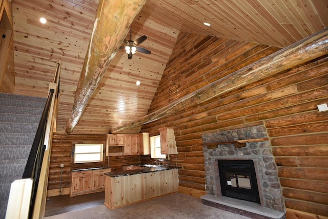 kitchen with light brown cabinets, a stone fireplace, rustic walls, wood ceiling, and light colored carpet