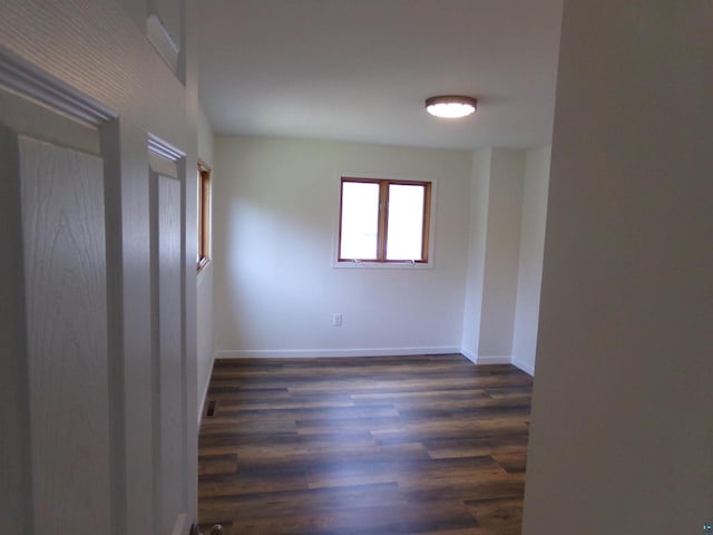 spare room with dark wood-type flooring