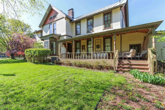 view of front of home with a front yard and central AC