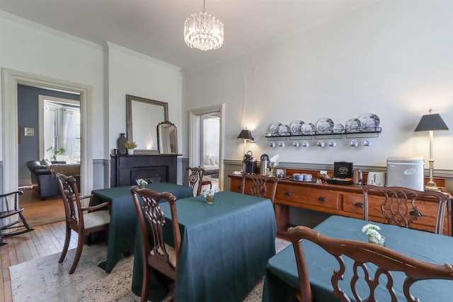 dining space with crown molding, hardwood / wood-style flooring, and a chandelier