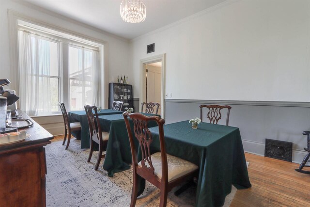 dining space with a notable chandelier, a healthy amount of sunlight, and hardwood / wood-style floors