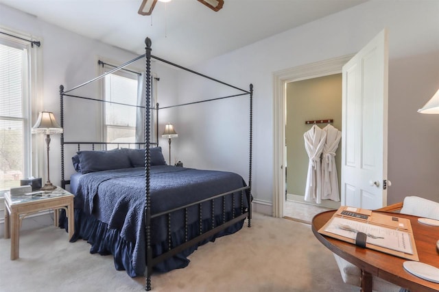 carpeted bedroom featuring multiple windows and ceiling fan