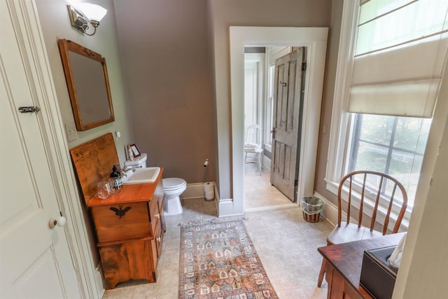 bathroom featuring tile flooring, vanity, and toilet