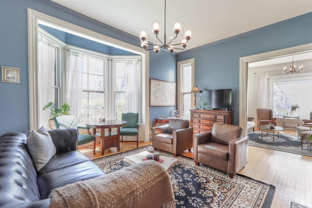 living room featuring a notable chandelier, ornamental molding, and hardwood / wood-style floors