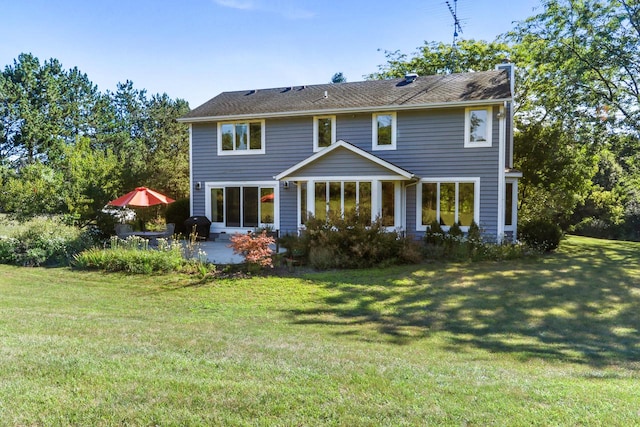 rear view of property featuring a yard and a patio area