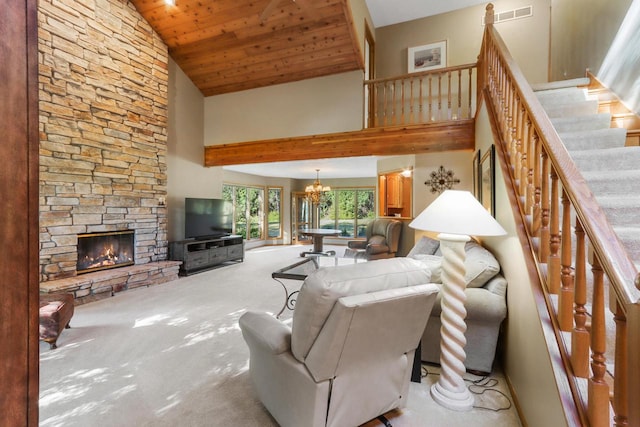 carpeted living room featuring a chandelier, a stone fireplace, wood ceiling, and high vaulted ceiling