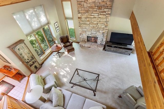 living room with high vaulted ceiling, carpet floors, and a fireplace