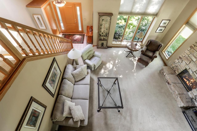 living room featuring a fireplace, carpet flooring, and a high ceiling