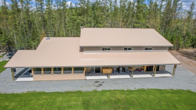 rear view of house featuring a lawn and a patio