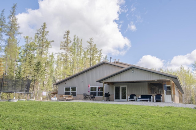 rear view of house featuring a yard, a patio area, and a trampoline