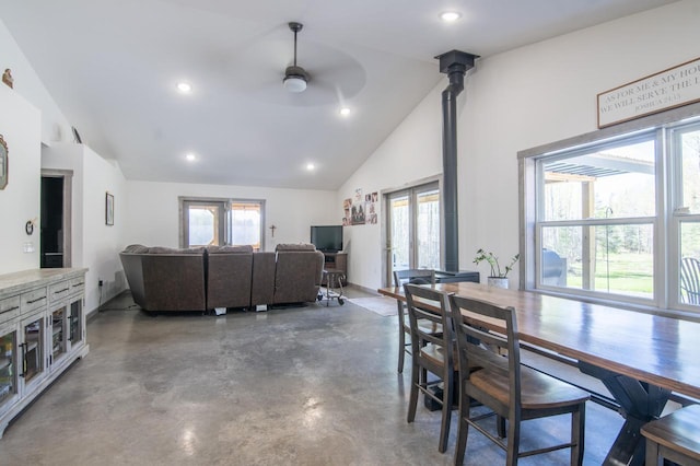 dining area with a healthy amount of sunlight, concrete floors, ceiling fan, and lofted ceiling