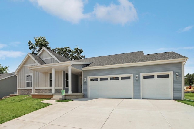 view of front of home with a garage, a front yard, and covered porch