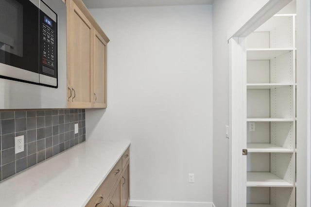 kitchen featuring light brown cabinetry and backsplash