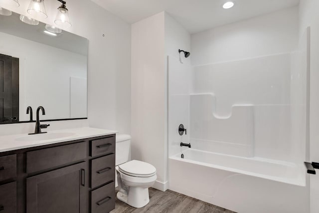 full bathroom with bathtub / shower combination, hardwood / wood-style flooring, toilet, and large vanity