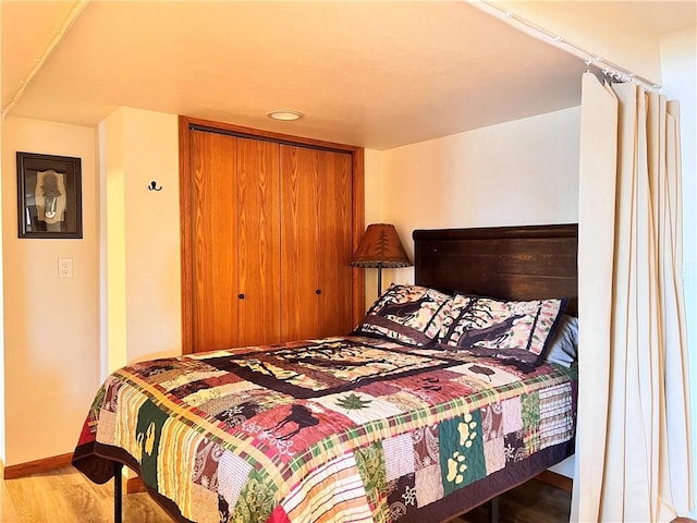 bedroom with wood-type flooring and a closet