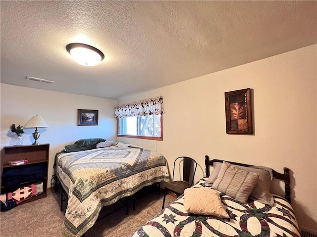 bedroom featuring carpet floors and a textured ceiling