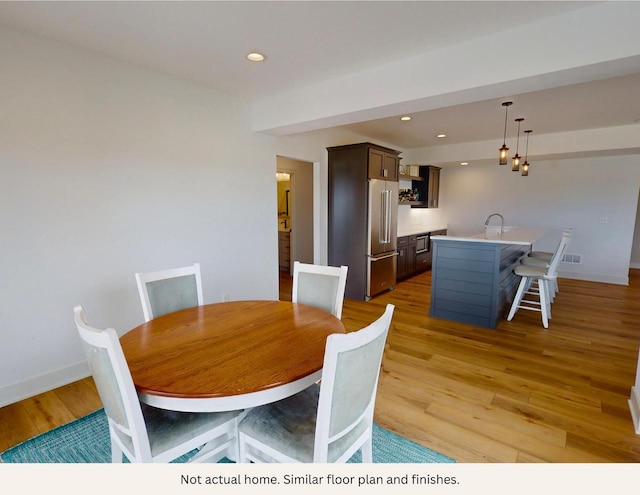 dining area featuring light wood-type flooring and sink