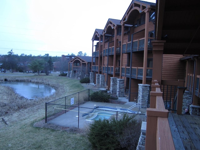 view of property's community featuring a swimming pool and a water view