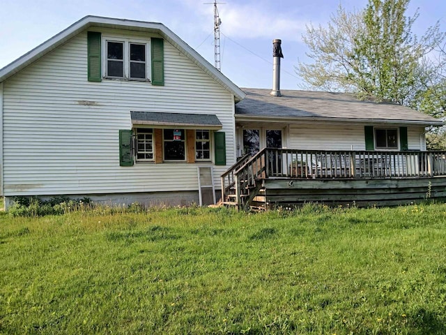 back of property featuring a deck and a lawn