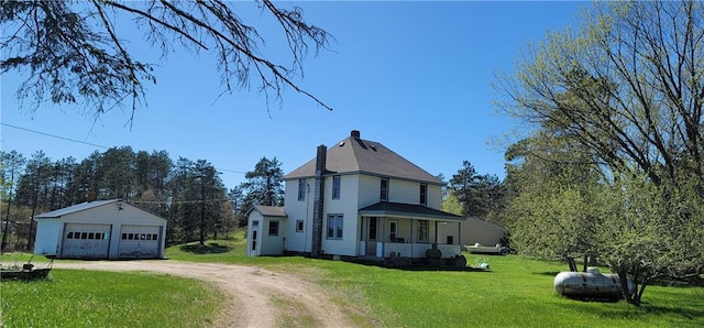 view of front facade with a front yard, a garage, an outdoor structure, and a porch