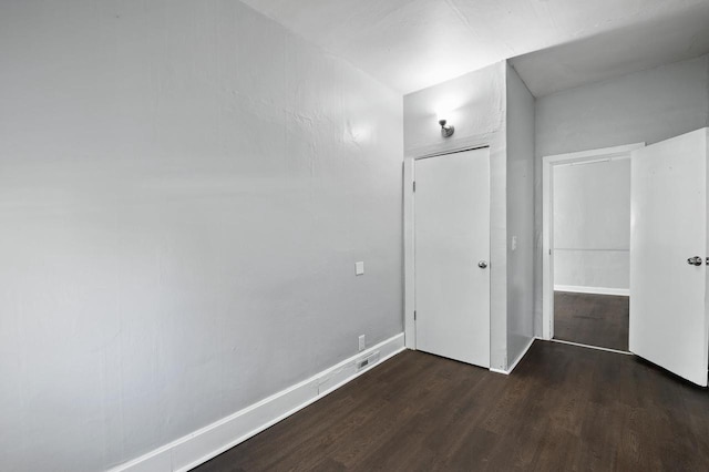 unfurnished bedroom featuring a closet and dark hardwood / wood-style floors