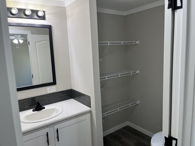 409 S Linden St, Adams, WI 53910 - bathroom with ceiling fan, crown molding, wood-type flooring, toilet, and vanity