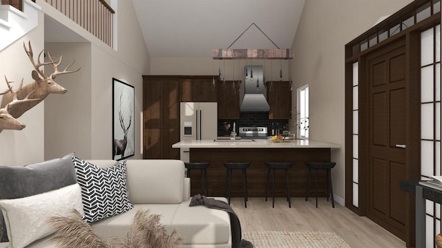 kitchen with backsplash, kitchen peninsula, light hardwood / wood-style floors, high quality fridge, and a breakfast bar