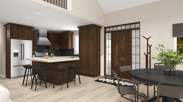 kitchen with a kitchen breakfast bar, light hardwood / wood-style floors, white fridge with ice dispenser, and wall chimney exhaust hood