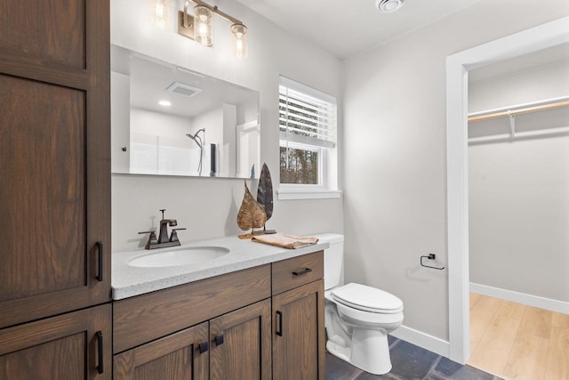 bathroom with hardwood / wood-style floors, vanity, toilet, and walk in shower