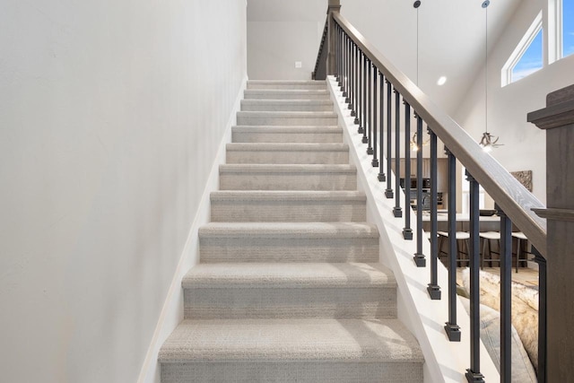 staircase featuring high vaulted ceiling