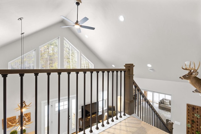 stairway with ceiling fan and high vaulted ceiling