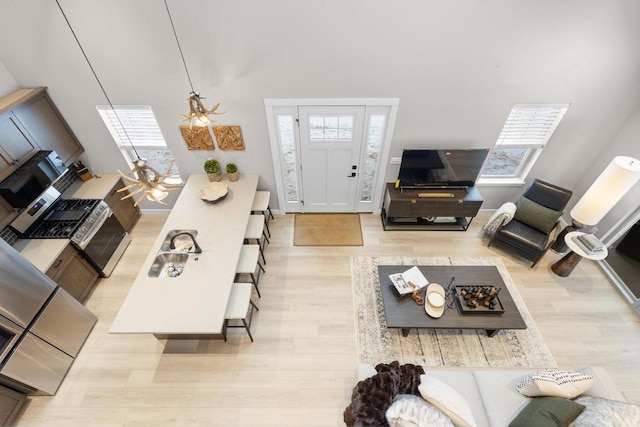 living room with sink, plenty of natural light, and light wood-type flooring