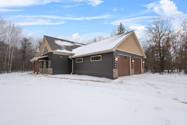 snow covered property featuring a garage