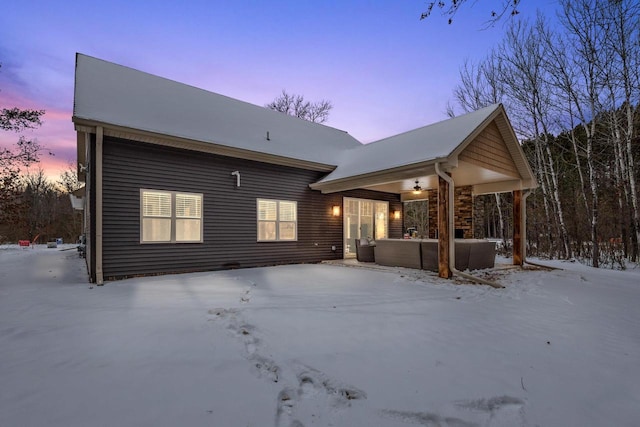 view of snow covered back of property