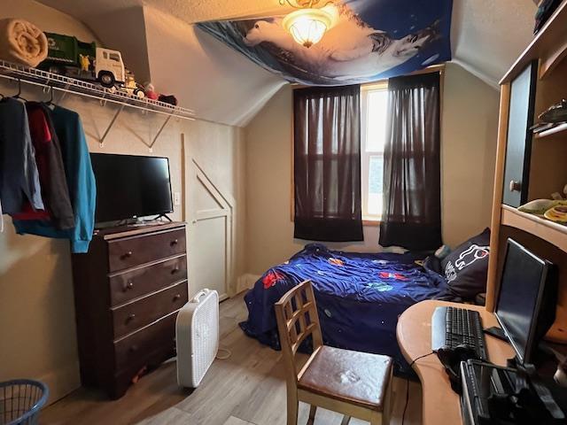 bedroom featuring vaulted ceiling and wood-type flooring