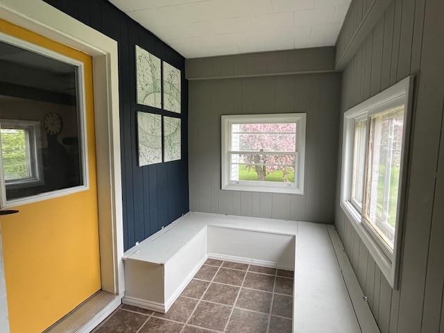 mudroom with dark tile flooring