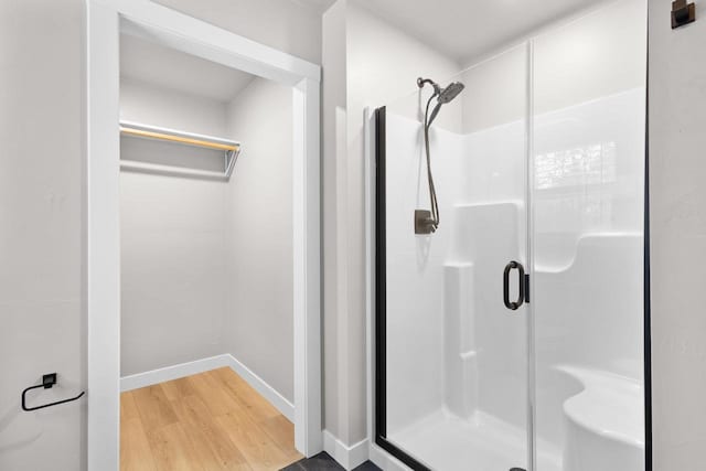 bathroom featuring a shower with door and hardwood / wood-style flooring