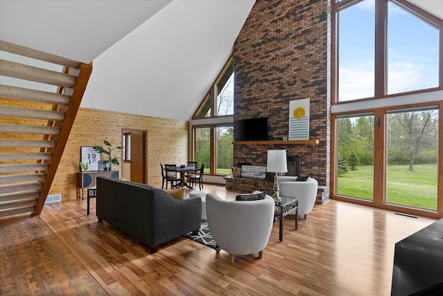 living room featuring high vaulted ceiling, hardwood / wood-style floors, and a wealth of natural light