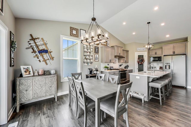 dining space with a notable chandelier, sink, vaulted ceiling, and dark hardwood / wood-style flooring