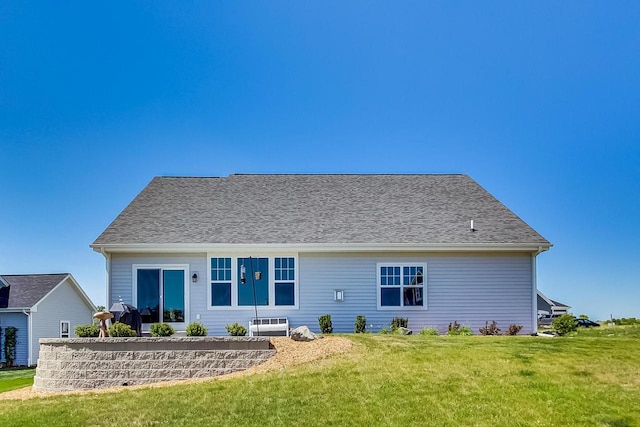 rear view of house featuring a yard