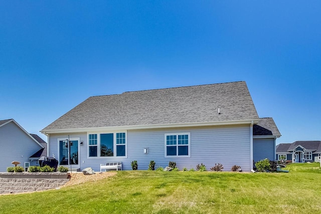 rear view of house featuring a lawn