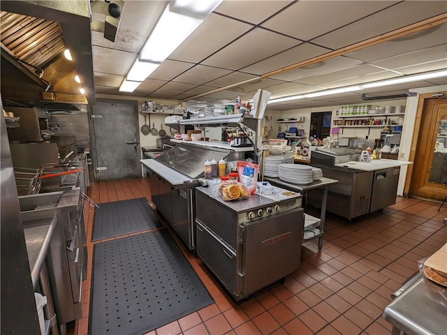 kitchen with a center island, dark tile flooring, and a paneled ceiling