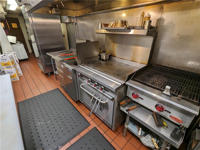 kitchen featuring stainless steel counters, stainless steel fridge, and light tile floors