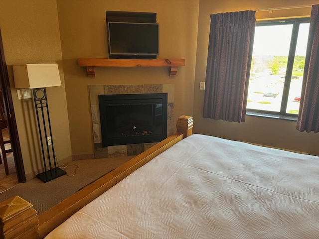 carpeted bedroom featuring a fireplace