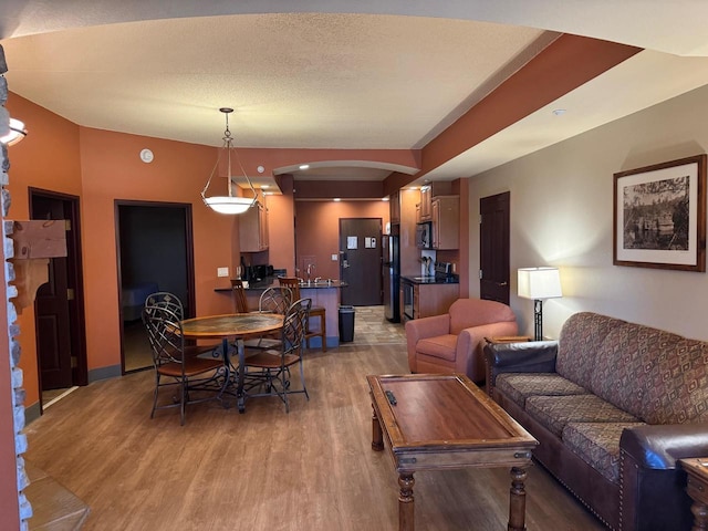 living room with wood-type flooring and a textured ceiling