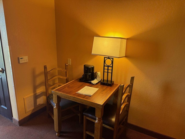 dining room featuring dark colored carpet