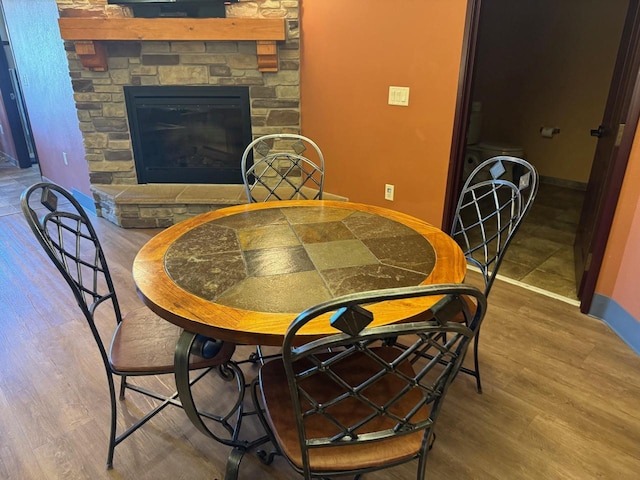 dining room featuring hardwood / wood-style flooring and a fireplace