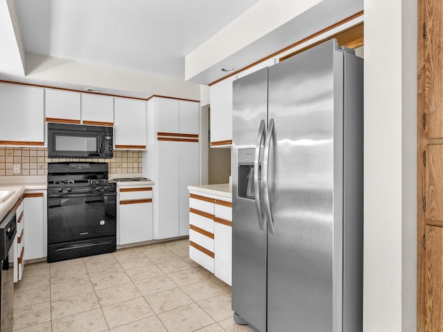 kitchen with white cabinets, tasteful backsplash, light tile patterned flooring, and black appliances